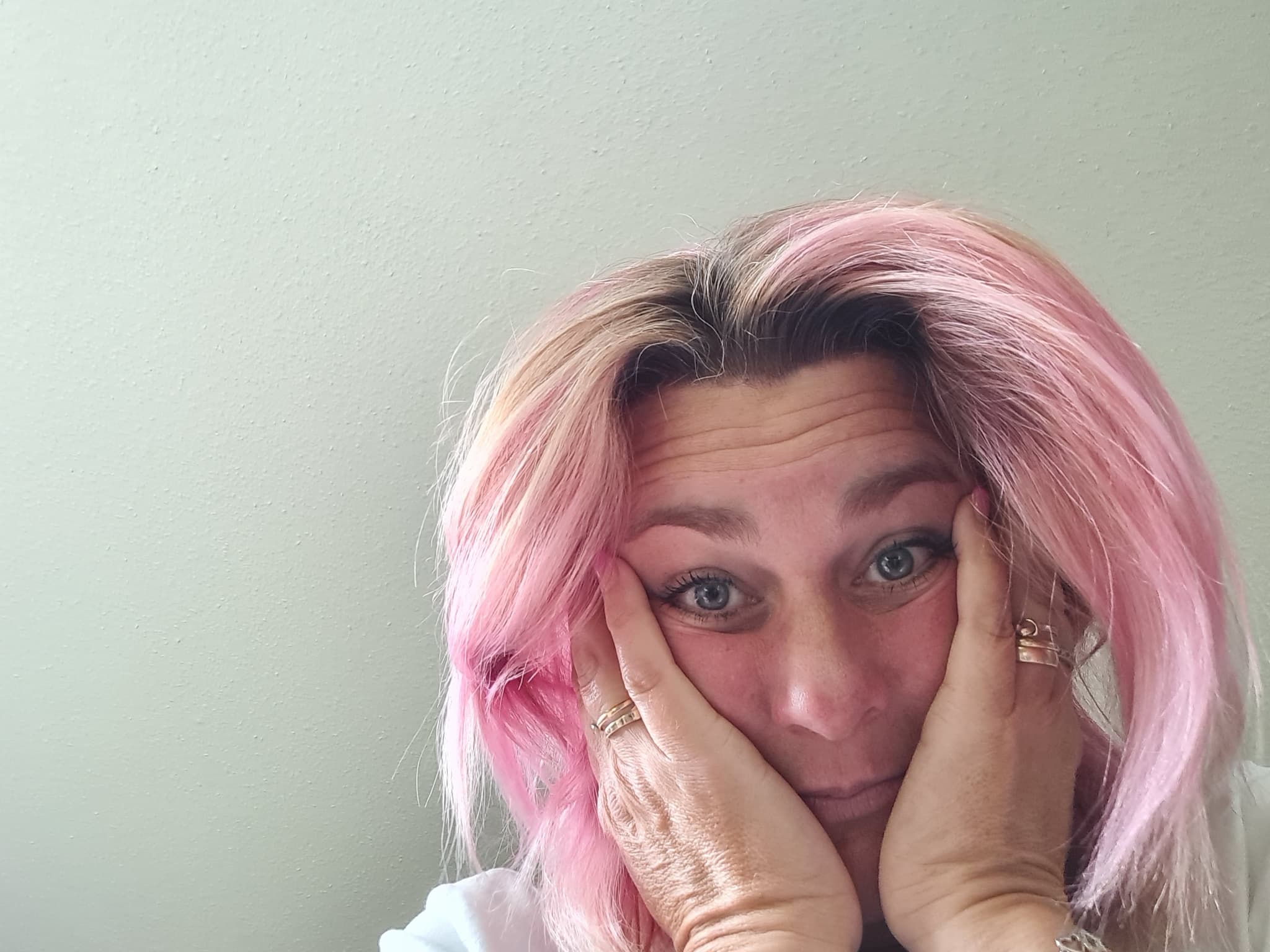 Nicky Welsh laughing, one hand in her pink hair